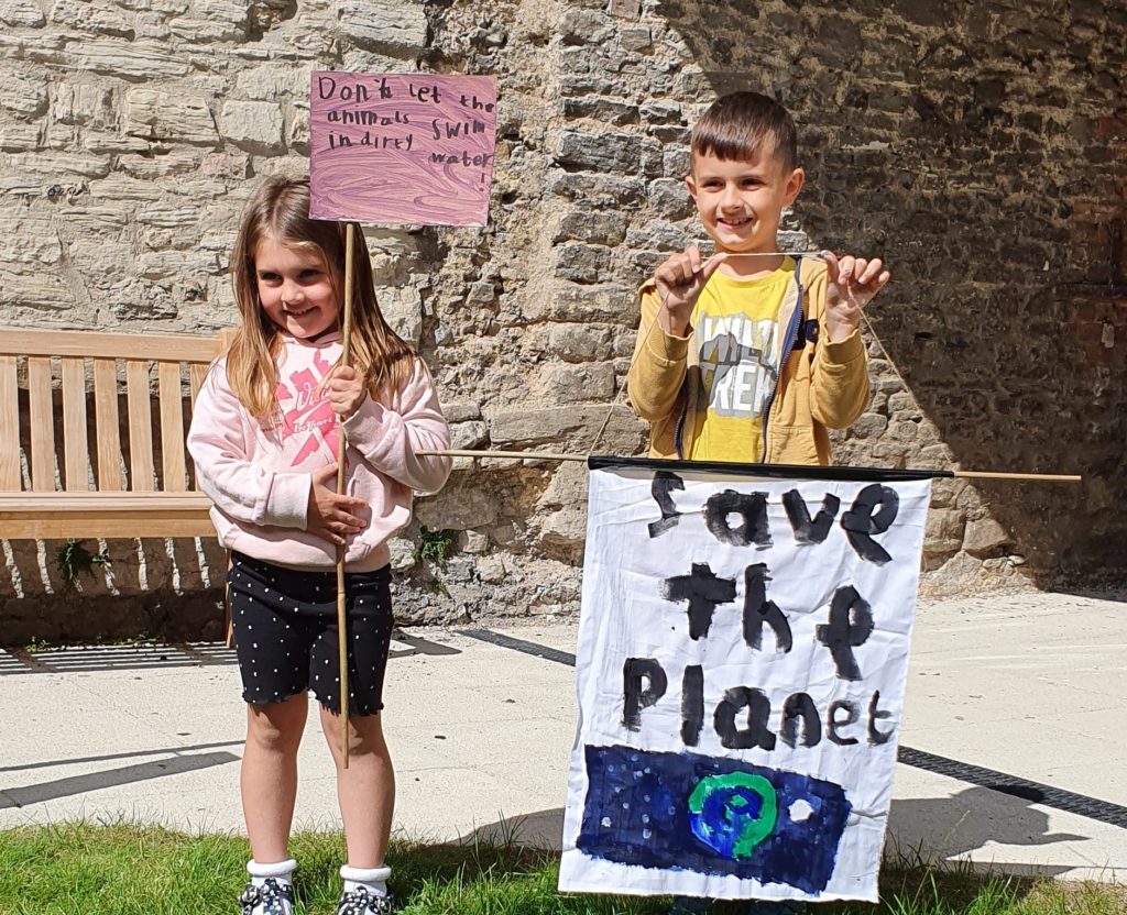 Two small children holding climate change protest banners