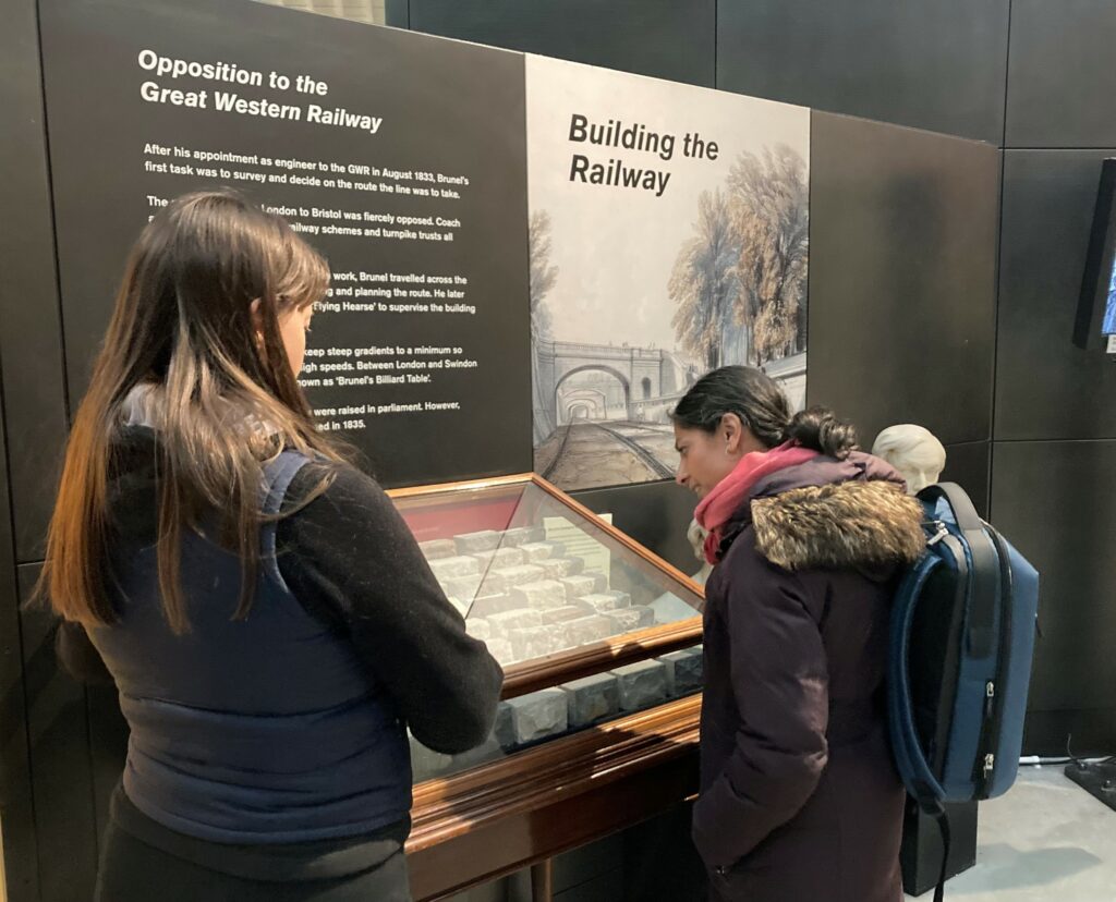 Two women looking at a museum display case.