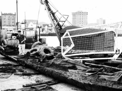 Photo of the logboat on Hamworthy Quay surrounded by boating equipment.